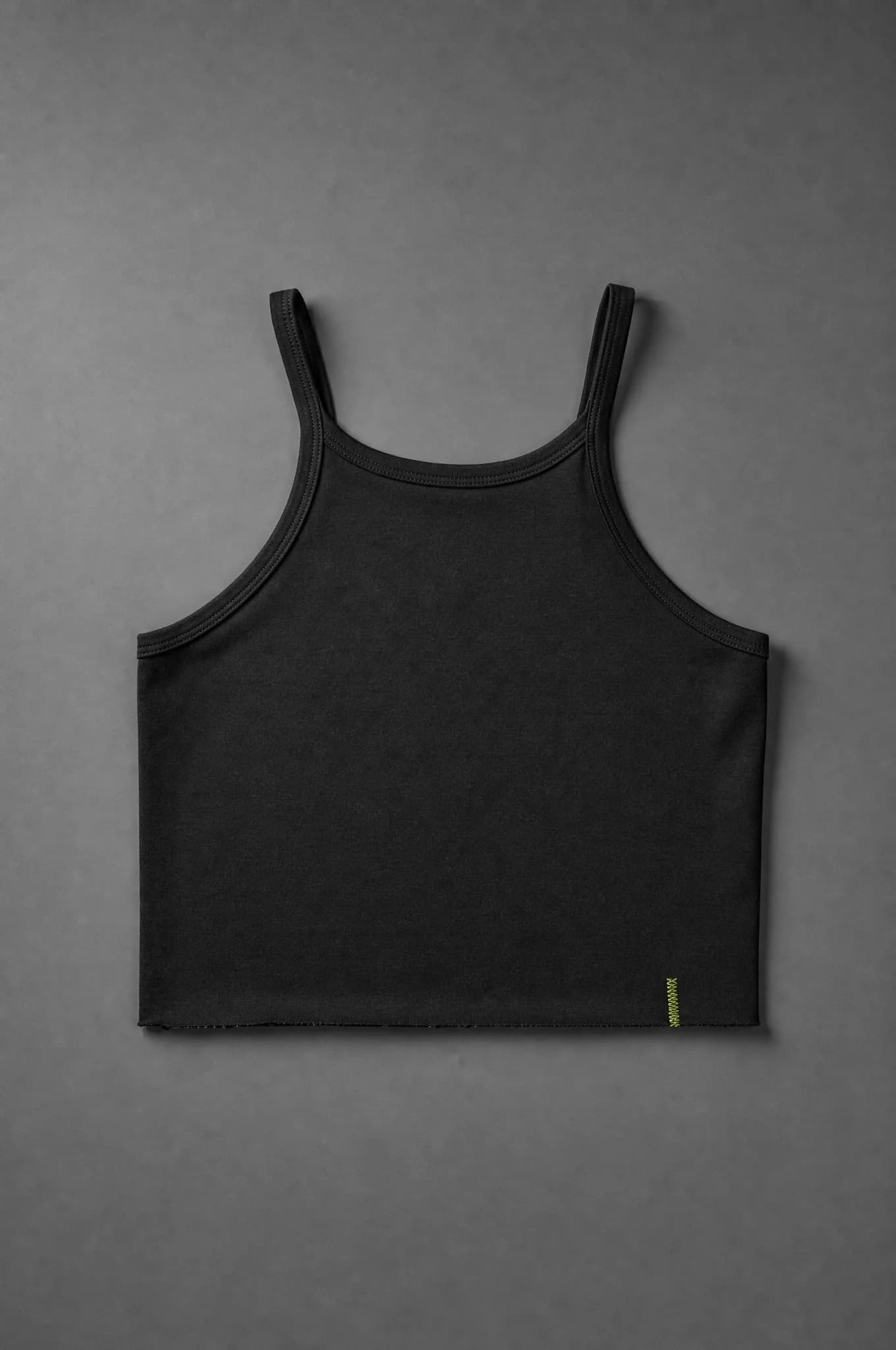A black cropped tank top photographed flat from above, empty and unworn, showing a raw-edge cropped hem and closed side seams.